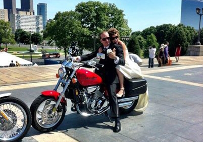 The couple riding a motorcycle on their wedding day.