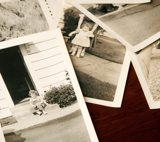 Vintage black and white photos sitting on top of a desk.