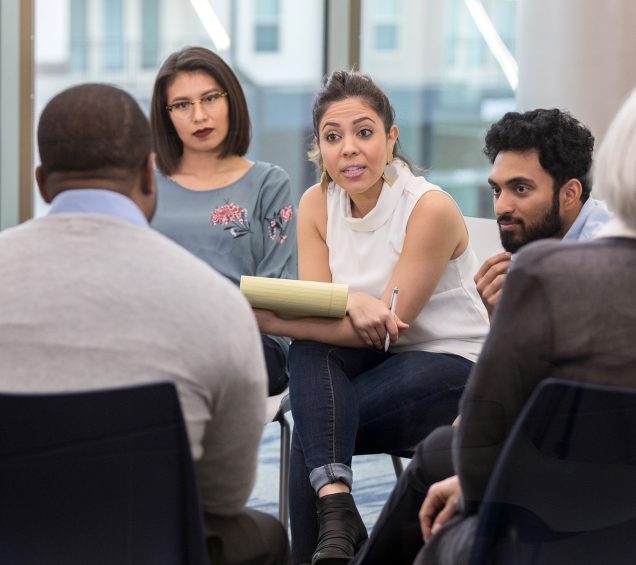 Woman physician holding a notepad and pen is directing a treatment session.