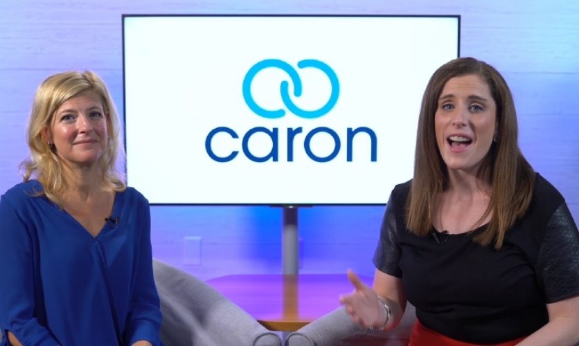 Two people, one of them Tina George, presenting in front of a screen with the Caron logo.