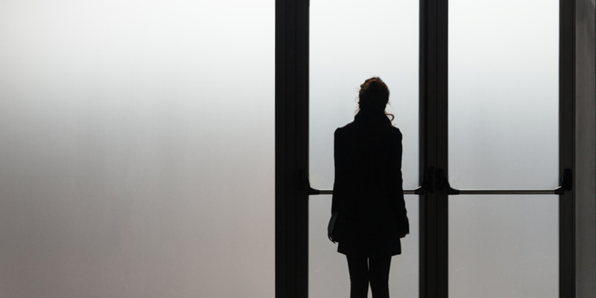 Silhouette in black of a teen in front of a misty glass door.
