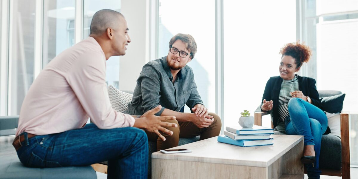Photo of two men and a woman talking