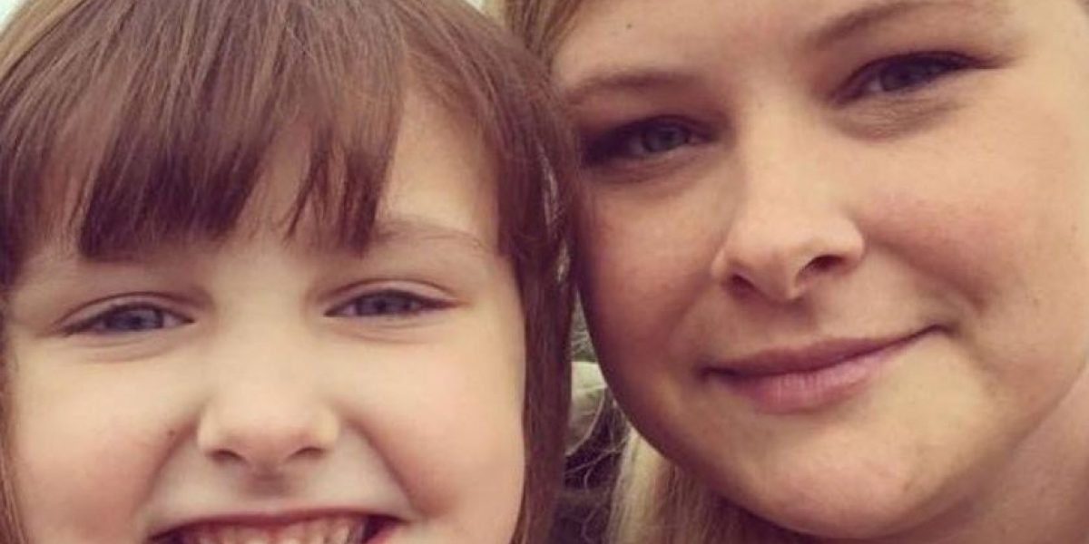 A close up of a woman and her young child smiling.