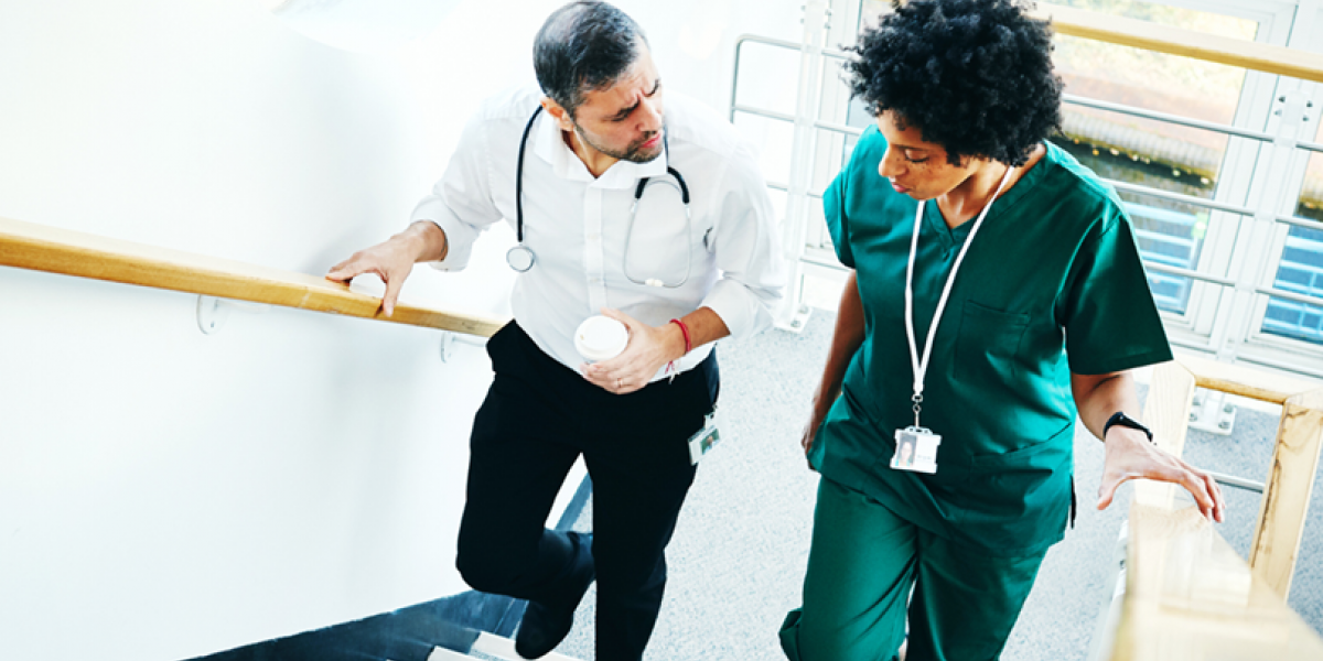Doctor and nurse in conversation, ascending stairs.