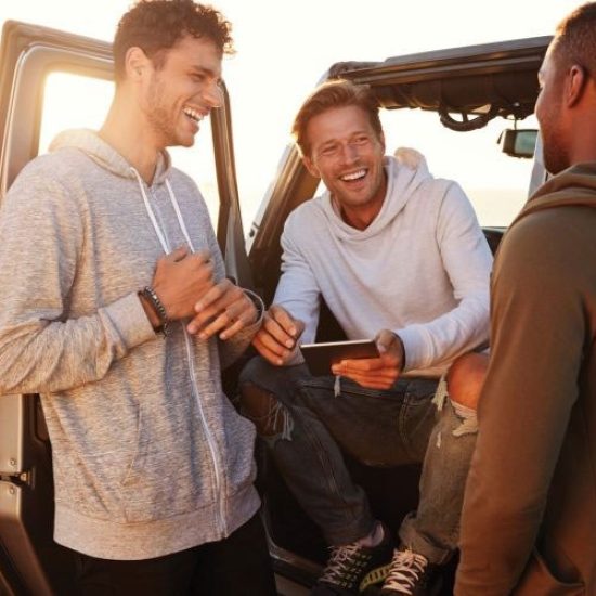 Men smiling next to jeep