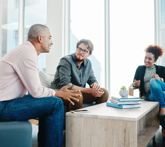 Photo of two men and a woman talking