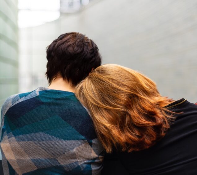 A man and a woman leaning on each other