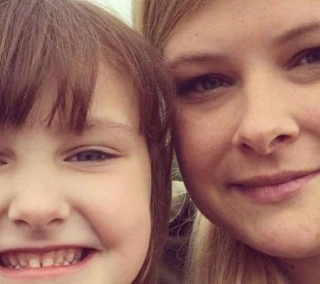 A close up of a woman and her young child smiling.